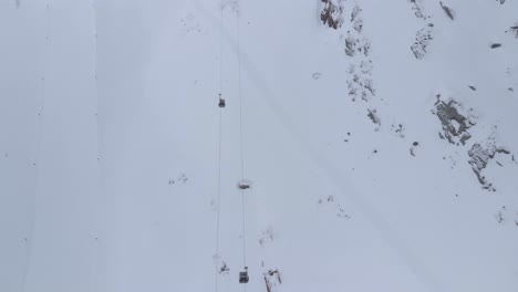 Aerial-view-over-ski-lifts-up-to-alpines-in-the-Kaunertal-alps,-in-Austria---tilt,-drone-shot