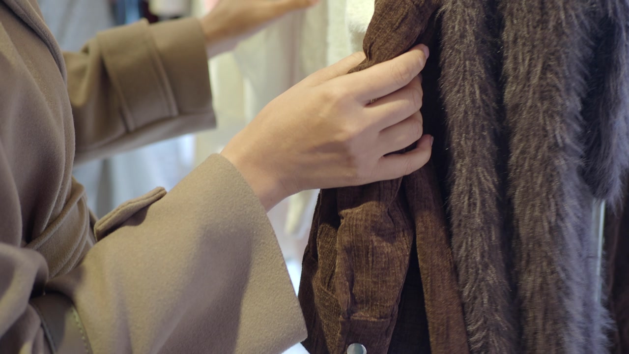 Close-up of a Hand Touching Clothes in a Retail Store