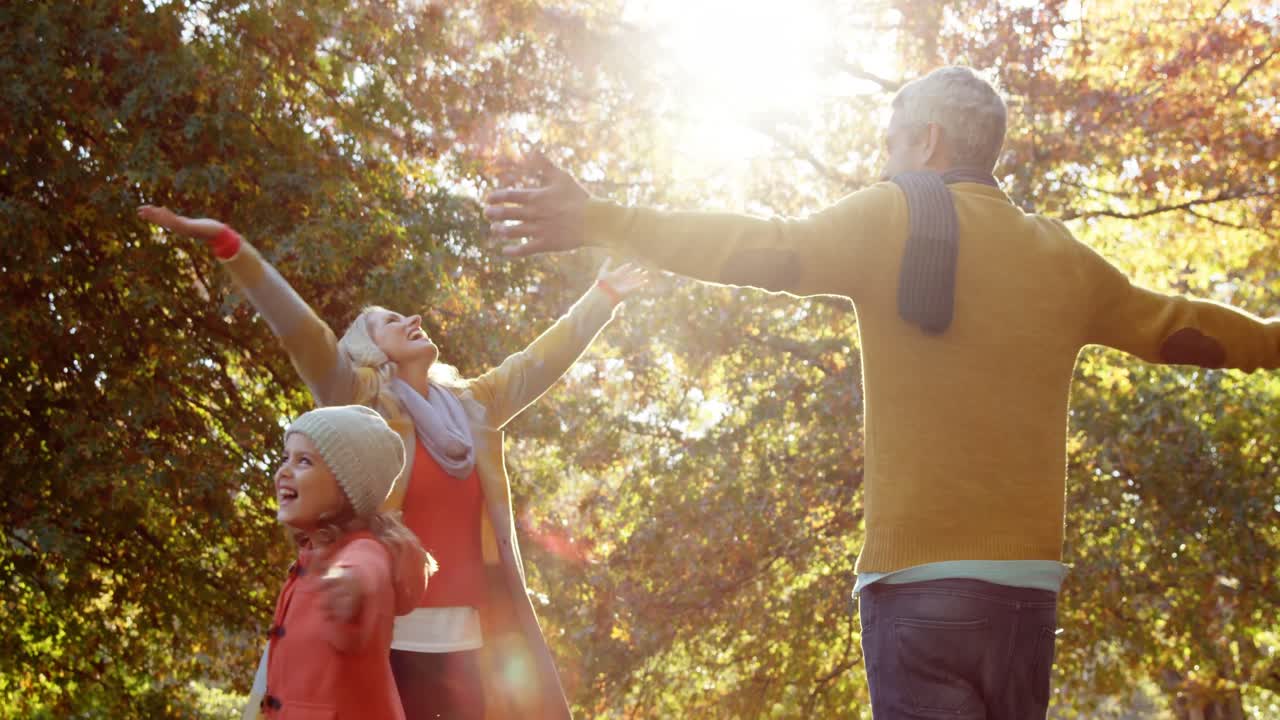 niña girando con los padres todos con las manos en alto