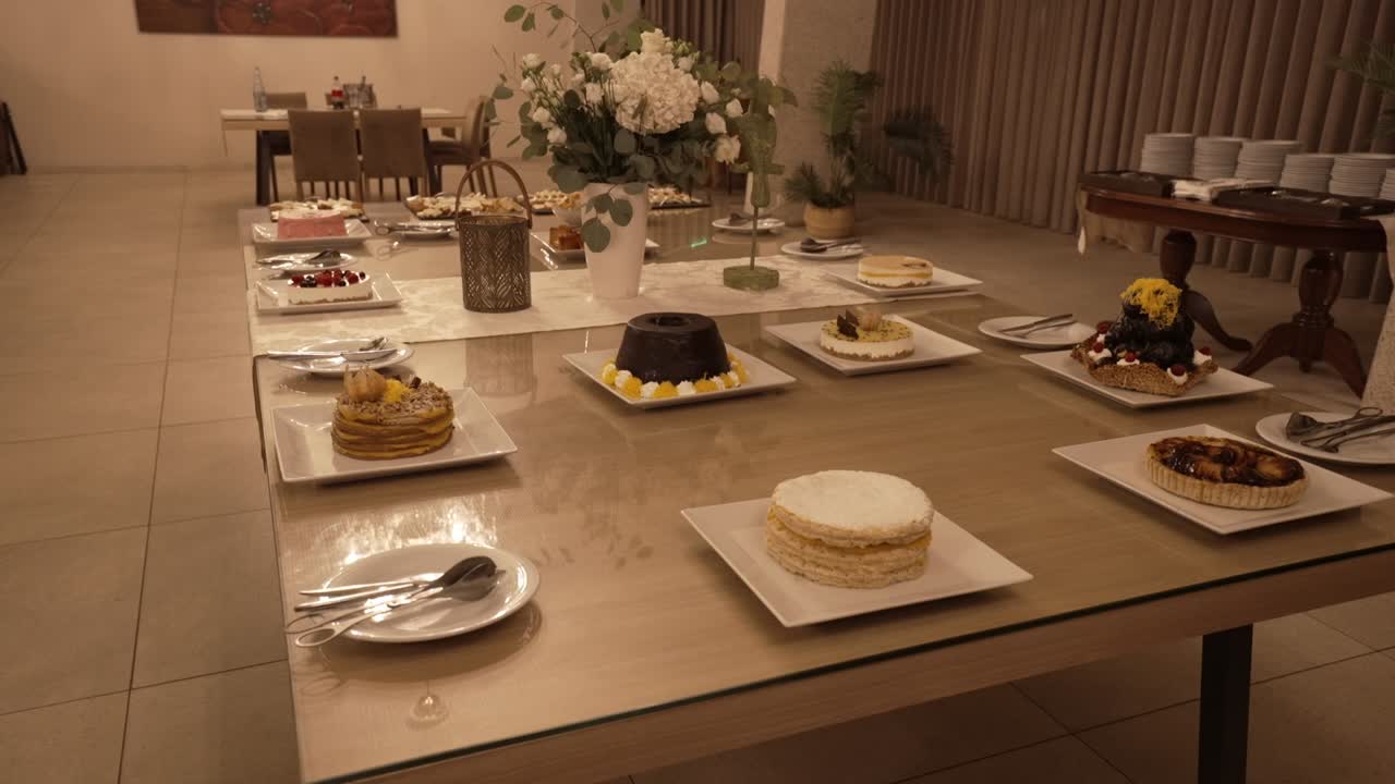 Assorted cakes and desserts arranged on a table in an elegantly decorated dining area