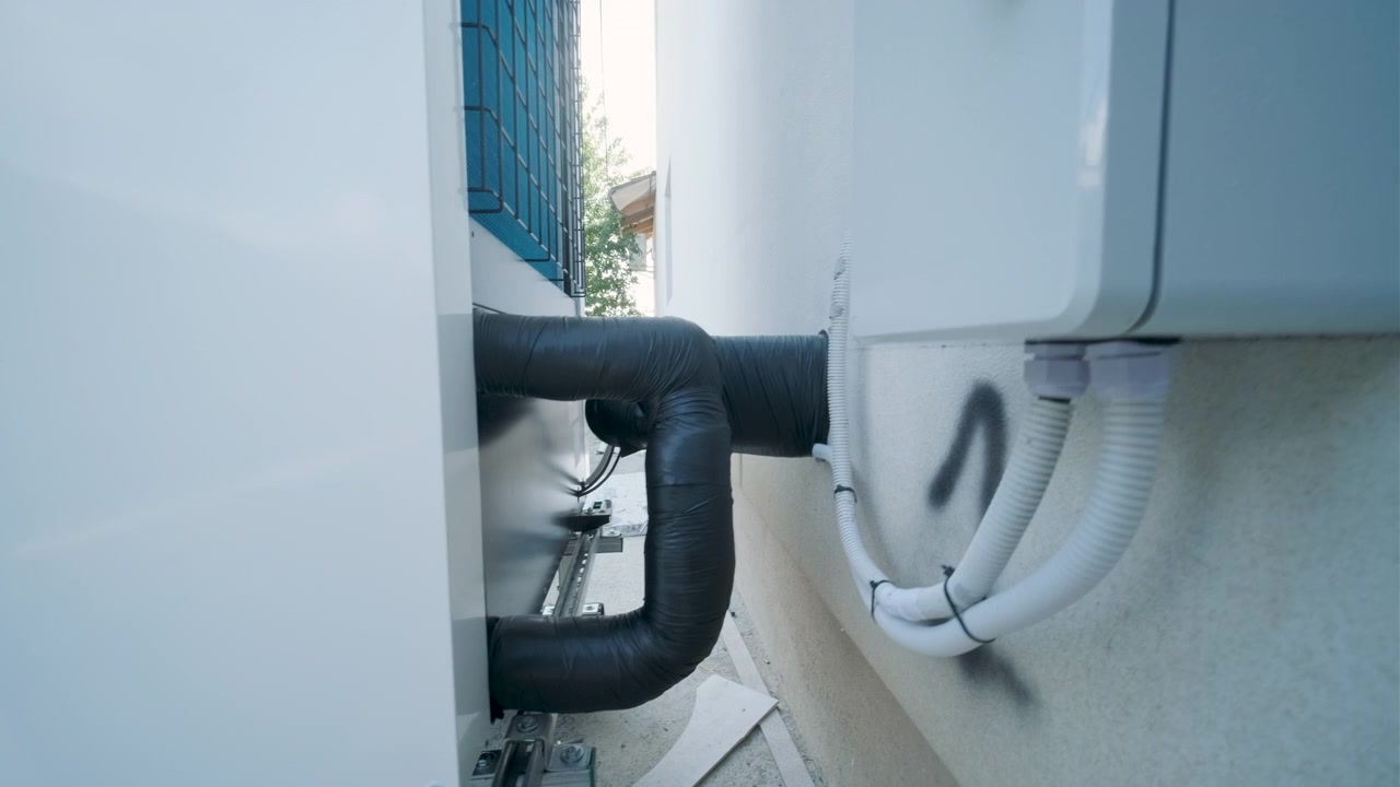 Outdoor Heat Pump Unit Installed Against Exterior Wall