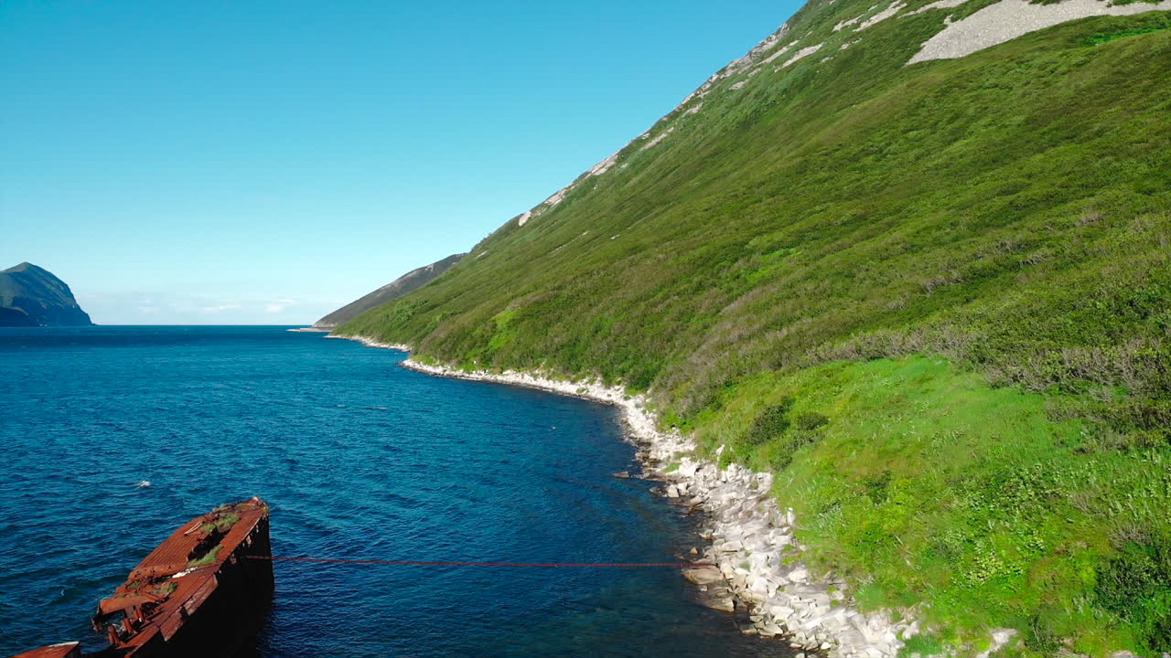 Shipwreck on a Coastal Beach with a Mountain