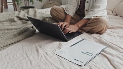 working on laptop on bed