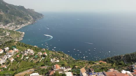 drone shot over ravello, italy's expansive cliffs overlooking the sea on a sunny day