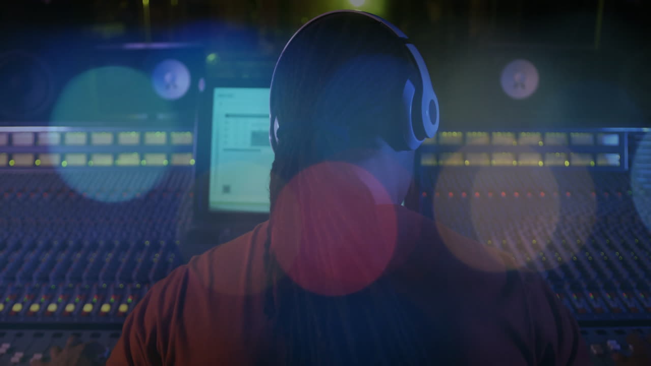 Audio engineer adjusting console faders in recording studio, with animated level meters rising