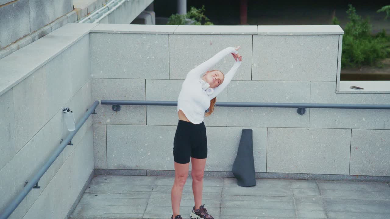 A woman stretching outdoors as part of a fitness workout