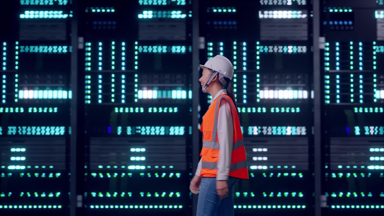 Side View of Asian Female Engineer Waving Hand Saying Bye While Walking in Server Room Data Center