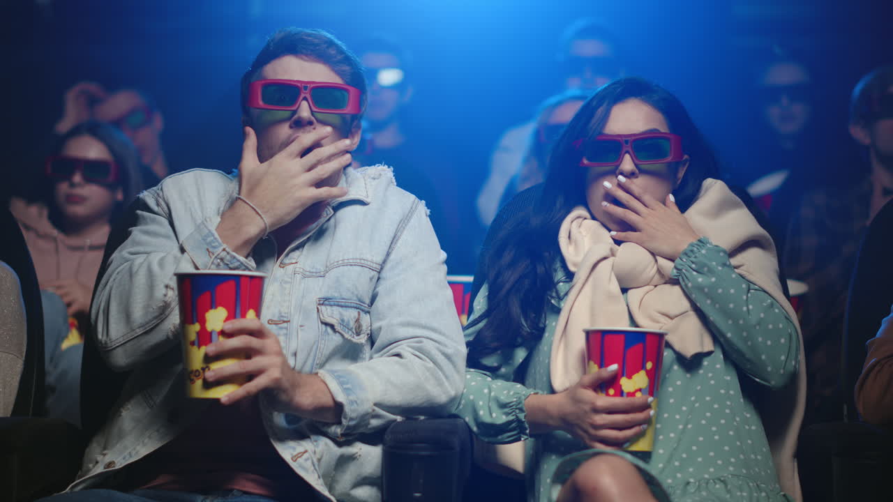 Scared people watching horror in cinema