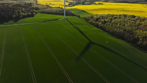shadow on the lawn from the blades of a rotating wind turbine. aerial