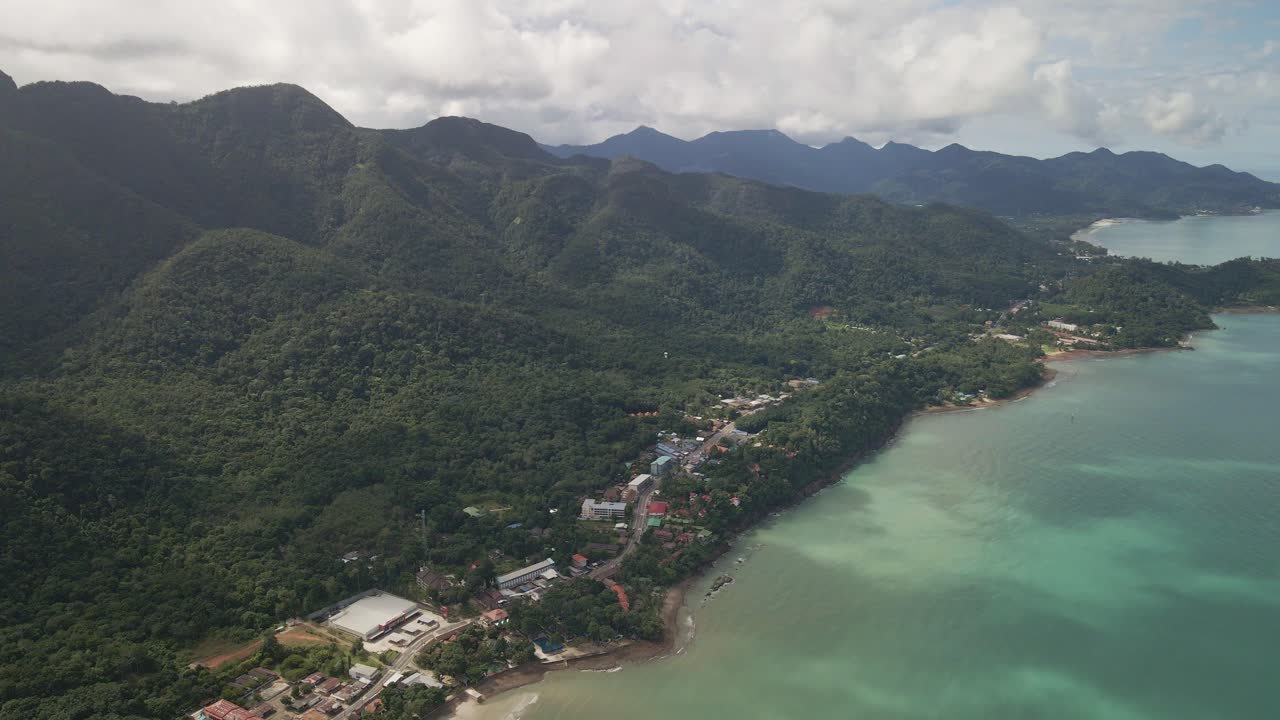 panorámica aérea de derecha a izquierda de una isla tropical con playa selvática y pueblo turístico en koh chang