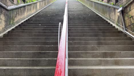 tilt-up shot of the flight of stairs leading up to a park on a rainy day