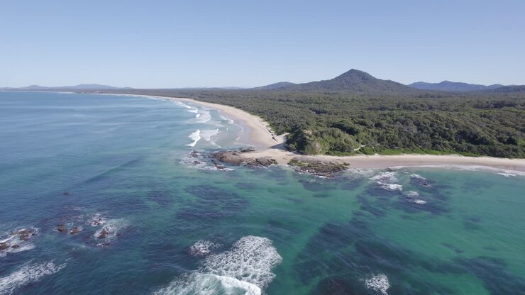 Paesaggio idilliaco di Wenonah Head di giorno a Urunga, NSW, Australia - ripresa aerea con allontanamento.