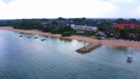 sea wall over seaside town and resort in sanur beach, bali island, indonesia