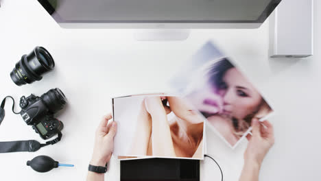 vista superior fotógrafo diseñador gráfico eligiendo imágenes de belleza trabajando en el escritorio desde arriba - dragón épico rojo