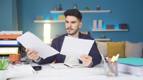 el trabajador de la oficina en casa que mira los documentos no está satisfecho.