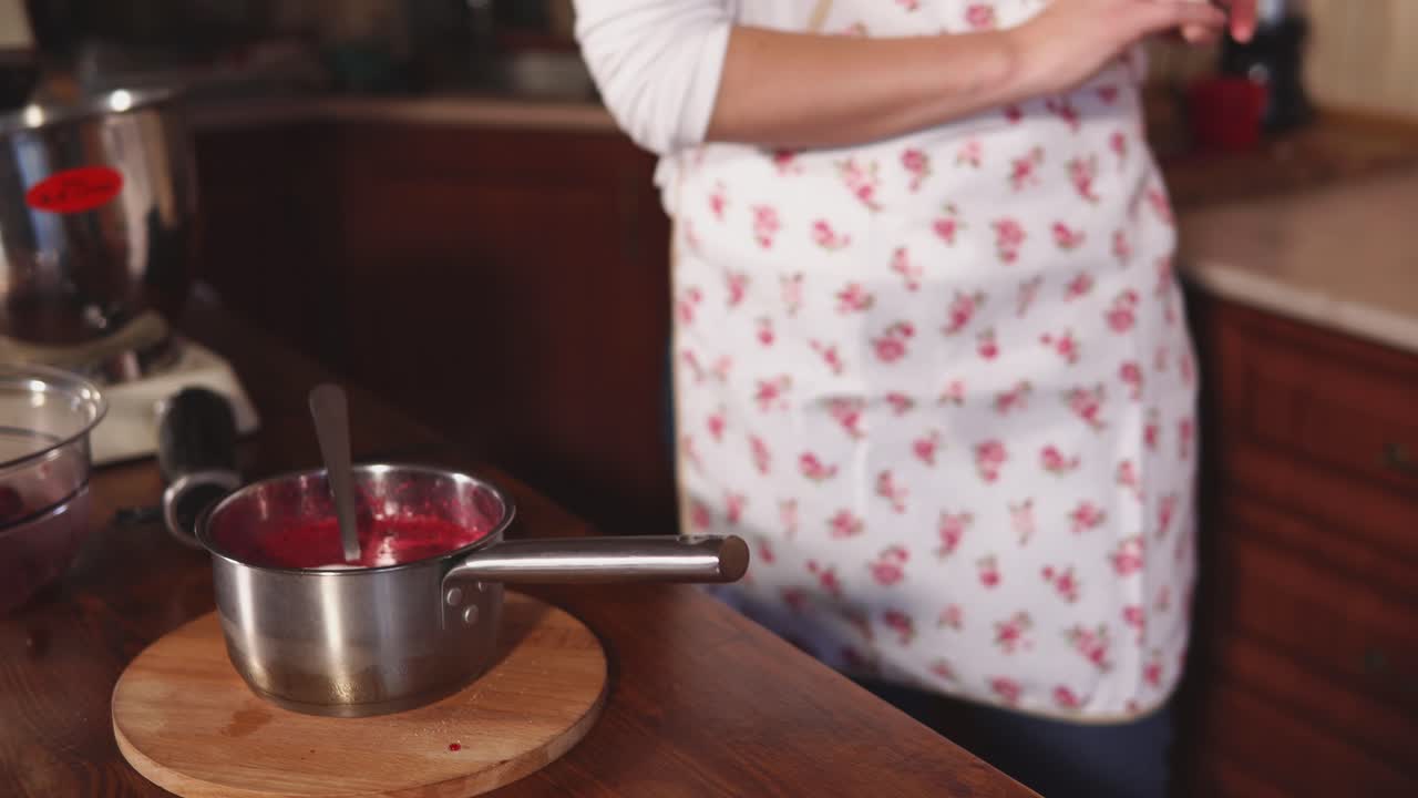 una mujer preparando mermelada de frambuesa.