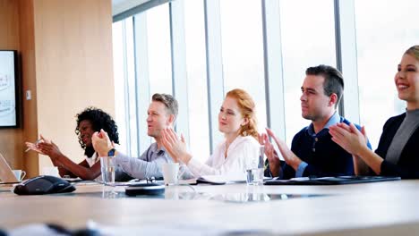 Executives-applauding-in-conference-room