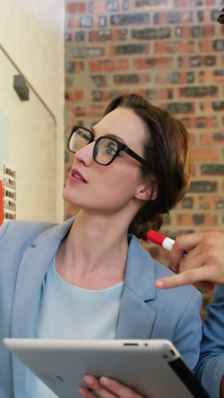 ejecutivo de negocios masculino y femenino interactuando a través de una tableta digital