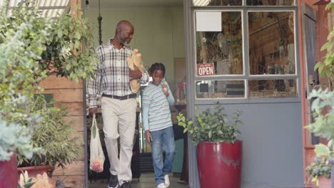 happy senior african american grandfather and grandson shopping at health food shop, slow motion