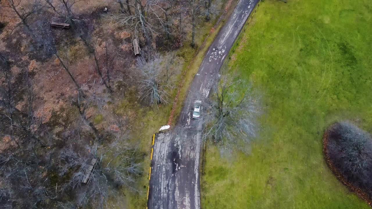 시골 풍경에서 도로를 통해 운전하는 은색 자동차