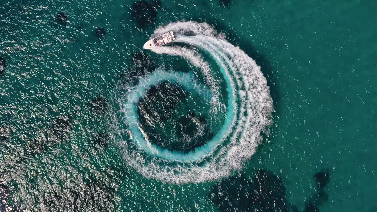 Aerial view of two motorboats forming a circle of waves