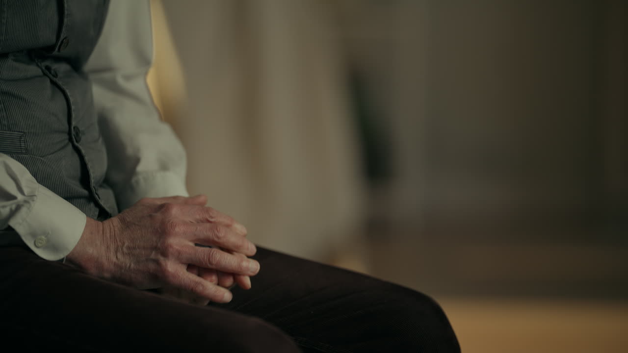 Close-up of a Person's Hands Resting and Clasping on Lap