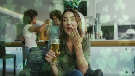 animación de tréboles sobre felices amigos diversos que usan artículos en forma de trébol y beben cerveza