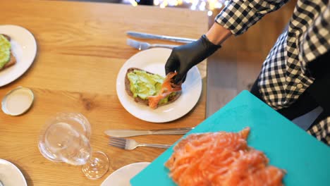 preparando tostadas de aguacate con salmón ahumado