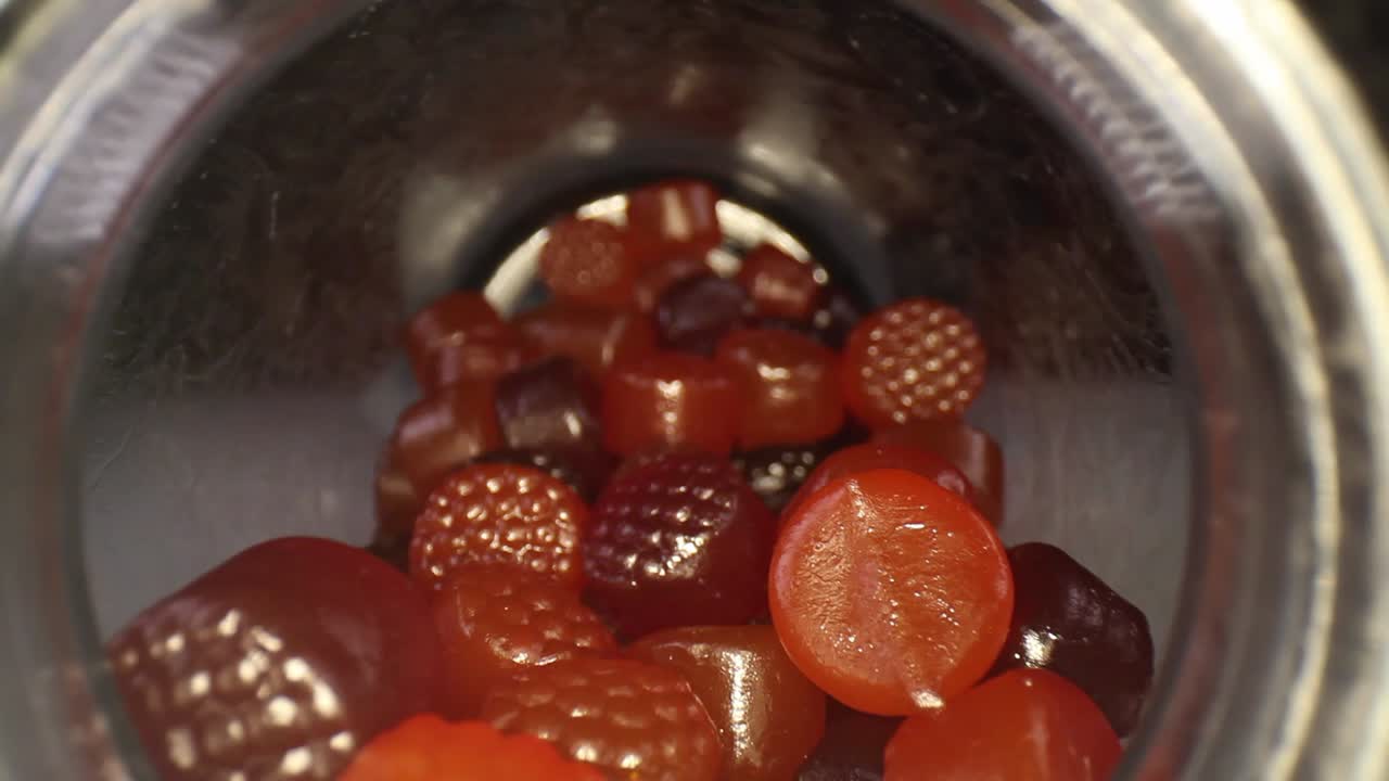 desde la apertura de la botella con la tapa parcialmente visible, empujando rápidamente hacia una botella de multivitaminas para adultos