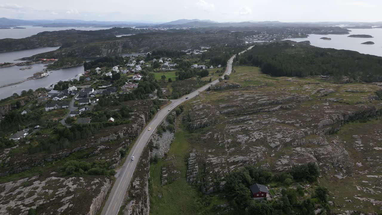 Cars Driving on Road in &Oslash;ygarden, Norway near Bergen with a Expensive Neighborhood next to the road and Beautiful Nature
