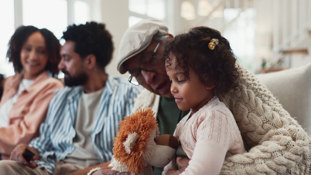 abuelo y nieta acurrucados en el sofá