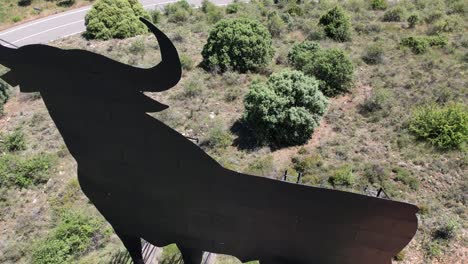 vista aérea del símbolo nacional español el toro de osborne, un enorme toro de metal en la cima de una colina