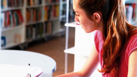 estudiante atenta haciendo la tarea en la biblioteca
