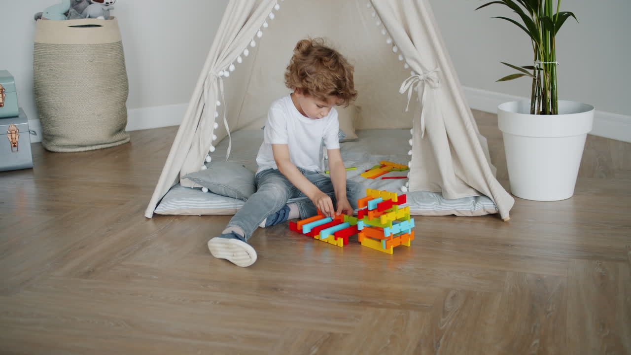 Little Boy Playing with Building Blocks in a Play Tent