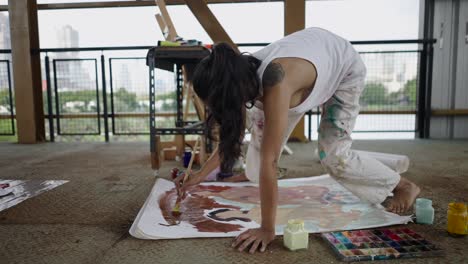 artist painting on the floor in an urban studio