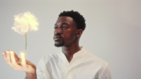 young man staring mesmerized at flower flying above his hand
