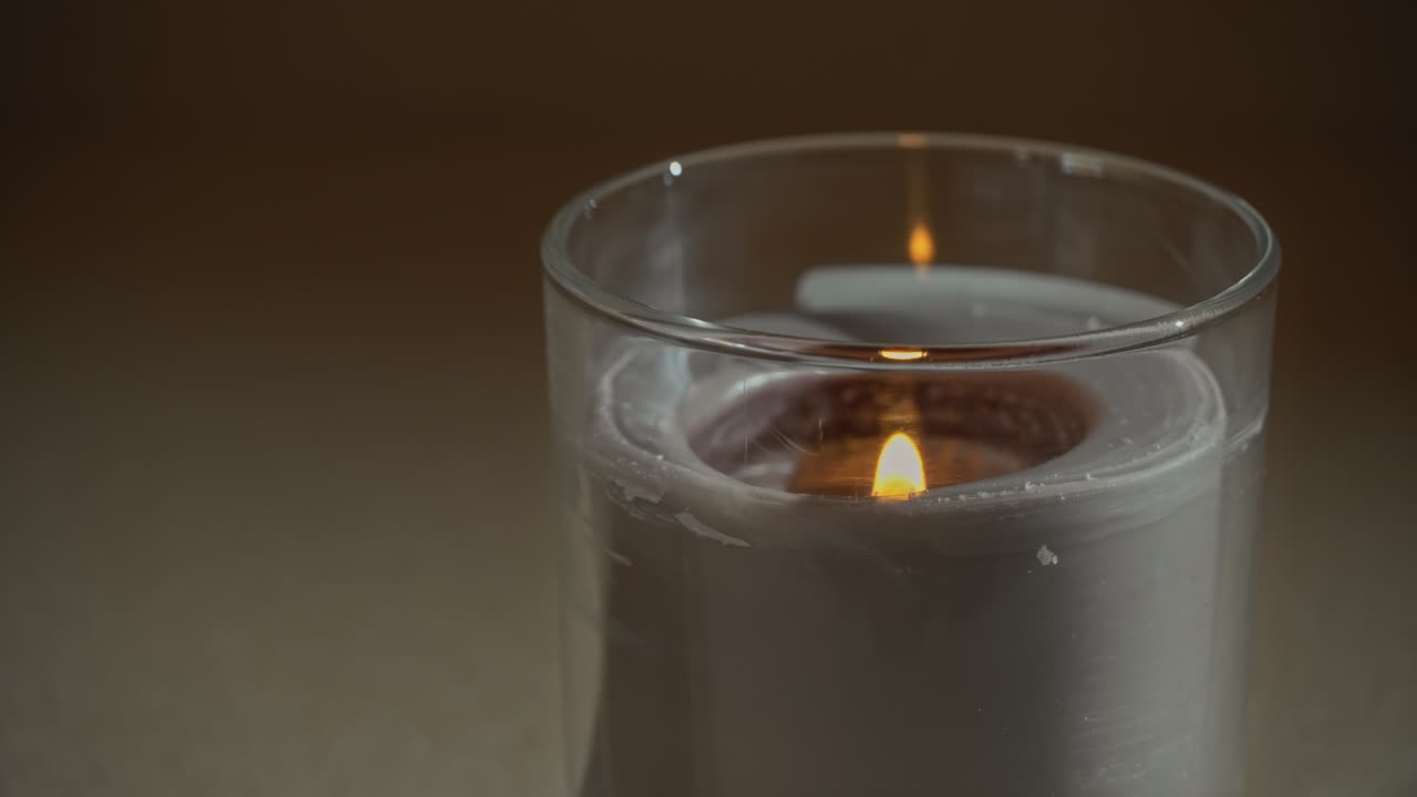atmosféricamente, una vela arde, emitiendo su propia sombra por la noche