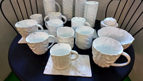 white mugs sale shop on display, marble texture finish table set, price tag