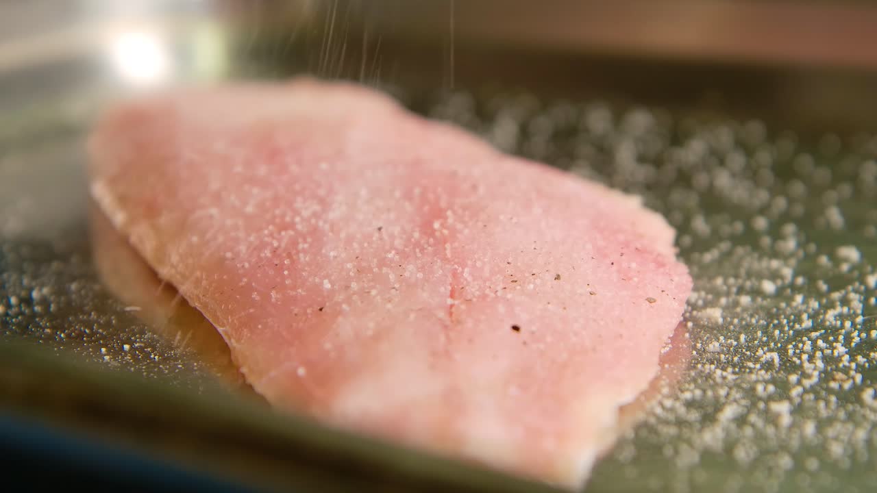 셰프는  ⁇ 은 스 ⁇ 퍼에서 신선한 가 ⁇ 운 피부 물고기 필레를 계절, 금속 팬에 맛에 따라 소금을 뿌립니다