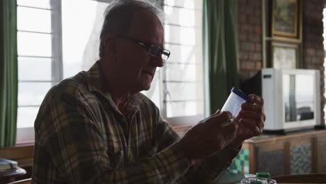 senior man with medical drugs at home