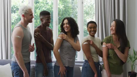 group of diverse young people showing their vaccinated shoulders at home