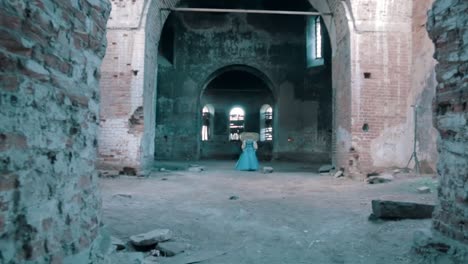 woman in a blue dress inside a ruined church