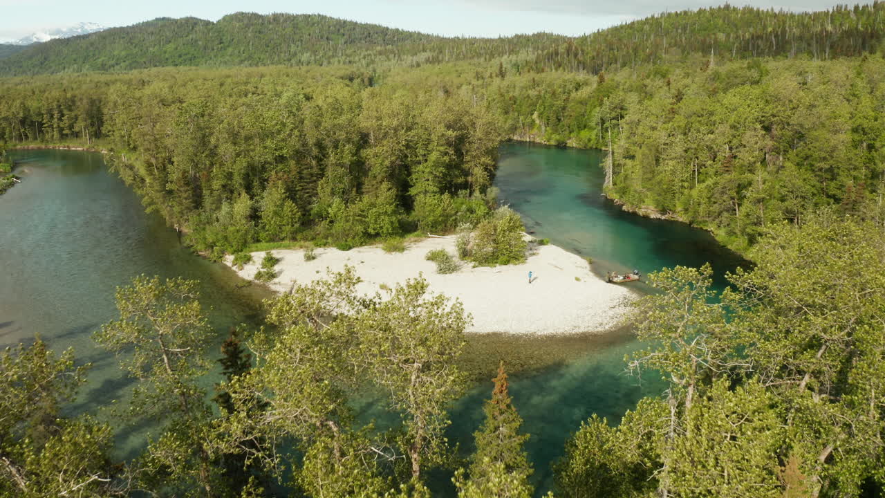 Beautiful green river bend revealed in the wilderness of Alaska with a boat parked on the shoreline