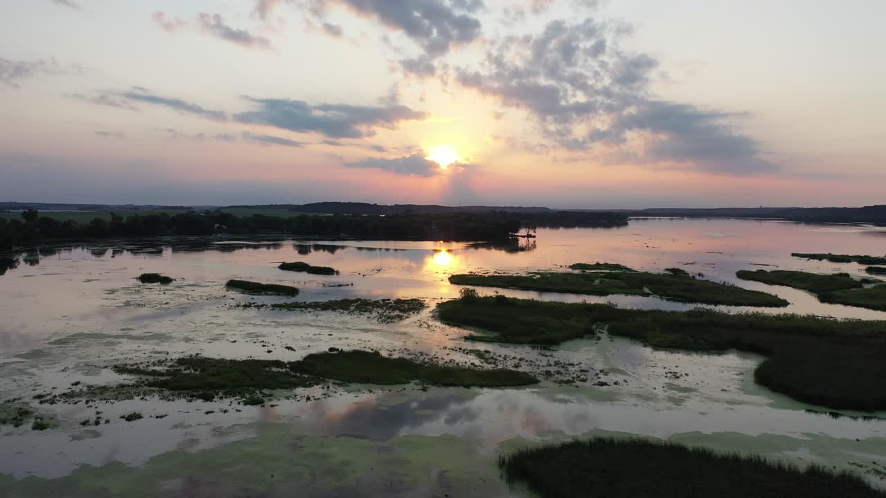 Pôr do Sol Sobre um Lago Tranquilo com Pântano e Ilhas