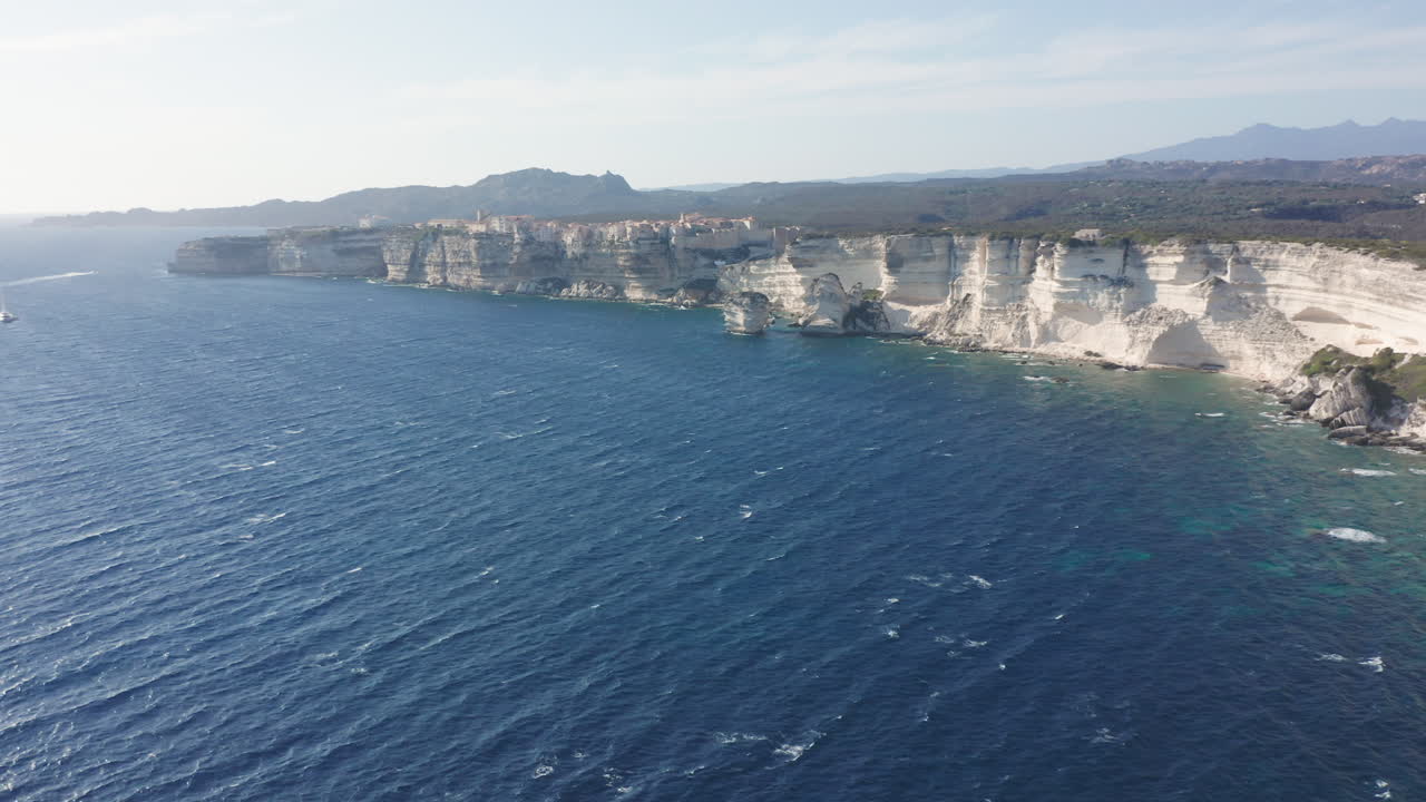 Bonifacio, Corsica aerial drone shot cliffs at sunset uplifting panorama rugged coastline limestone the turquoise Mediterranean Sea iconic French island landscape
