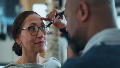 optician examining a woman's eyes