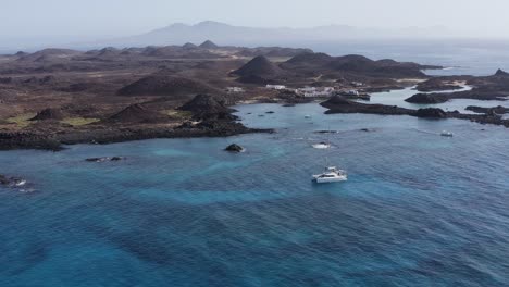 aerial view of a volcanic island with a yacht