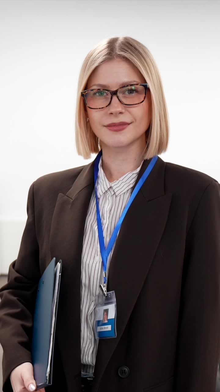 Profesjonell blond kvinne står på kontor med ID-kort