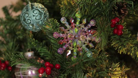 putting iridescent rainbow snowflake decoration on christmas tree