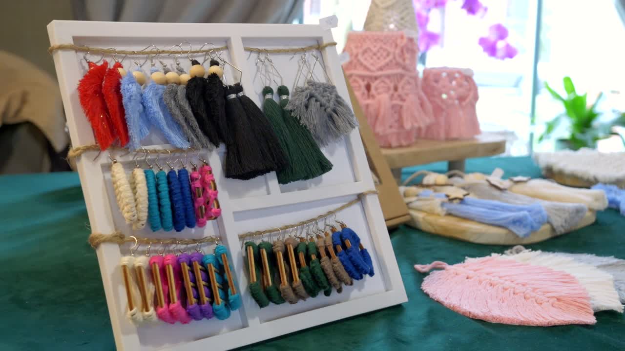 다채로운 섬유 펜던트 가 나무 로 된 스탠드 에 매달려 있다